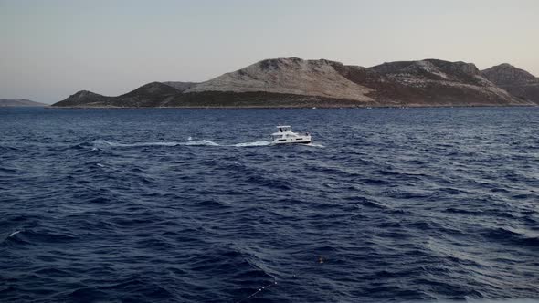 A White Motor Yacht is Sailing in the Sea on Waves During Summer Season at Windy Day