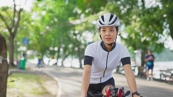 Asian young beautiful woman  in sportswear riding bicycle for health in the evening in public park