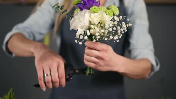 Closeup View of Hands of Professional Female Floral Artist Preparing a Bouquet Florist Cutting