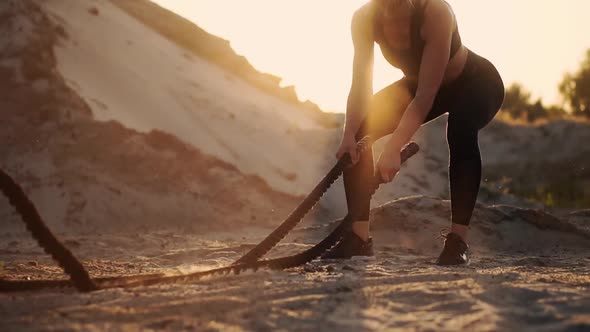 Athletic Woman Doing Crossfit Exercises with a Rope Outdoor