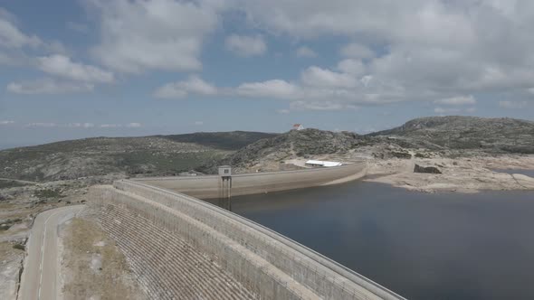 Drone rises and tilts over a wall at a lagoon in Portugal.