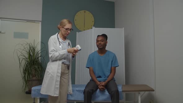 Doctor Measuring Body Temperature with Digital Thermometer Indoors