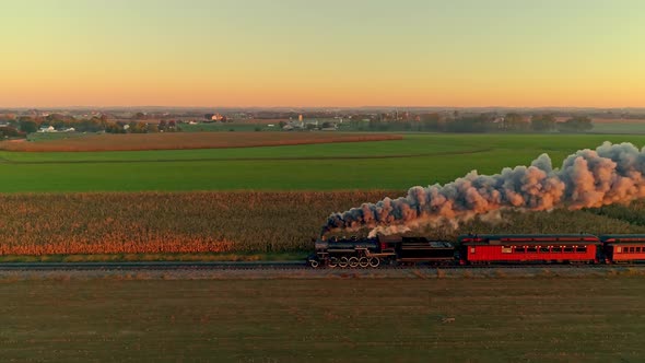 Steam Engine with Passenger Cars at the Golden Sunrise