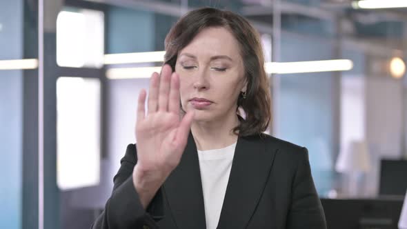 Portrait of Serious Middle Aged Businesswoman Asking To Stop By Hand Gesture