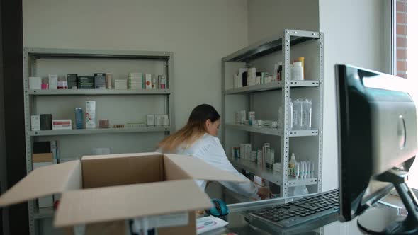 Young Caucasian Woman Packing Up Medicine Stuff in Box for Online Customer