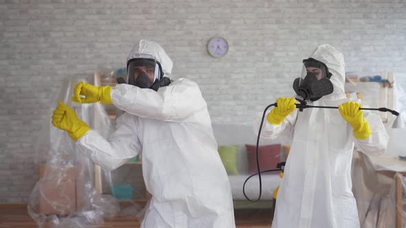 Cleaning Service Workers or Scientists in Protective Overalls Dancing