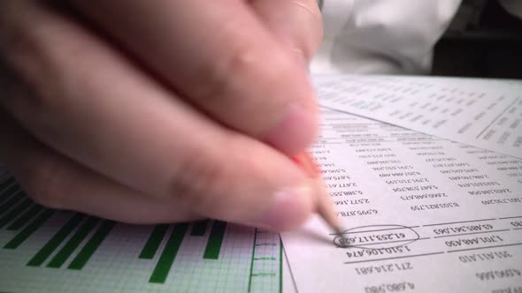 Accountant Analyzing Business Marketing Data on Paper Dashboard at Office Table