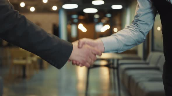 Close Up of Two Businessmen Greeting or Shaking Hands As a Sign of Successful Completion of Meeting