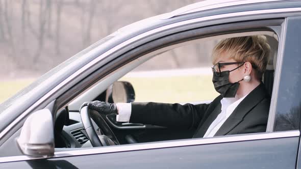 The Businesswoman in Black Style Wearing Protective Mask Is Driving a Car