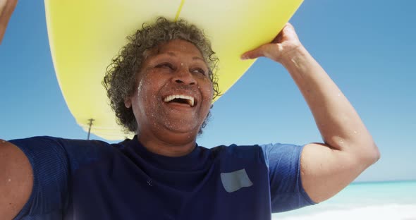 Senior woman with a surfboard at the beach