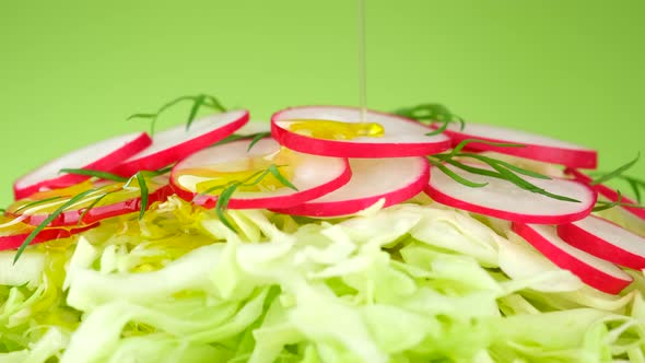 Pour Olive Oil on Fresh vegan Salad. Vegetable Fresh Salad with cabbage and radish.