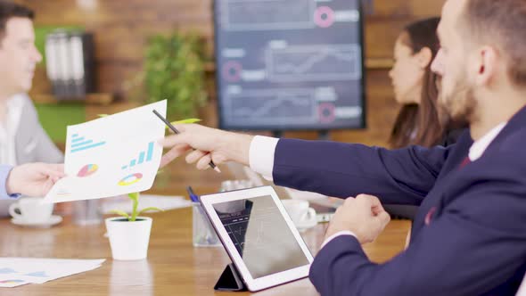 Businessman in Suit Analysing Charts on His Tablet