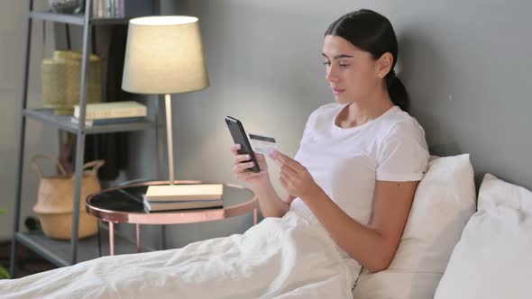 Online Payment Success on Smartphone By Latin Woman in Bed
