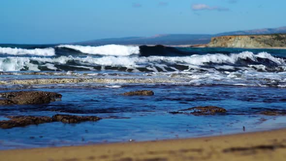 Dark Blue Sea Waves Splashing on Sandy Beach on Sunny Summer Day. Foamy Waters of Mediterranean Sea