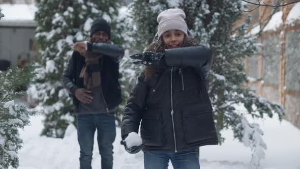 Medium Shot of Funny African American Teen Girl and Blurred Man Dancing in Slow Motion on Snowy