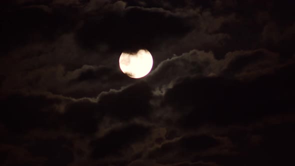 Moon rising through clouds time-lapse