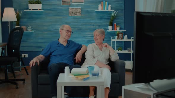 Retired Couple Watching Comedy Movie on Television at Home