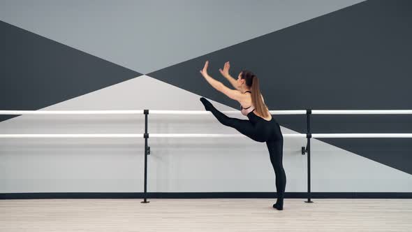 Woman Stretching Legs on Handrails in Dance Studio