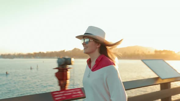 Happy Attractive Woman Walking By Pier, Enjoying Summer Sunset with Water View