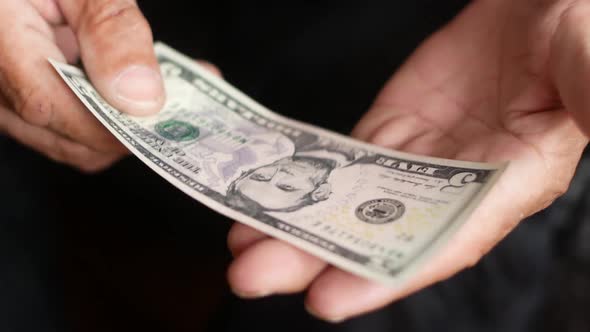 Close-up of a 5 American dollar bill in the hands of a man