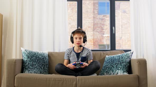 Boy with Gamepad Playing Video Game at Home