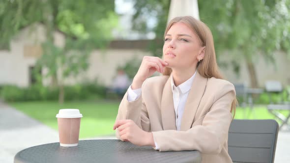 Young Businesswoman Thinking in Outdoor Cafe