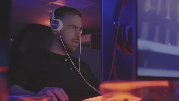 Gamer in Headphones Playing Online Shooter