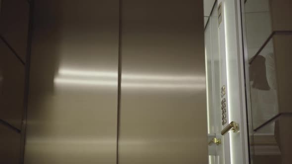 Elevator Door Opens and Shy Stressed Young Woman Walking Out. Portrait of Beautiful Brunette