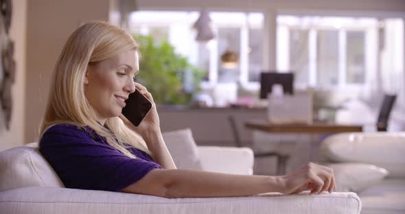 Beautiful Blonde Woman Relaxing on Couch Having a Call