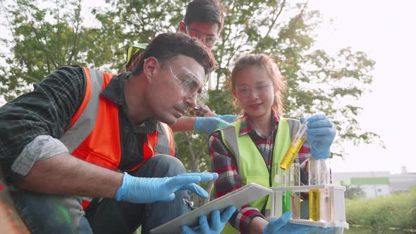 Ecologist and assistants check contaminants in factory wastewater in a test tube