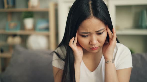 Unhappy Asian Female Student Is Feeling Bad Having Headache