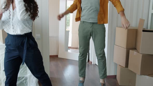 Tiltup Slow Motion of Man and Woman Dancing Relaxing Having Fun in New Apartment with Boxes Around