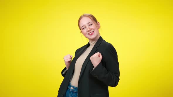 Positive Excited Young Businesswoman Making Victory Gesture Posing at Yellow Background