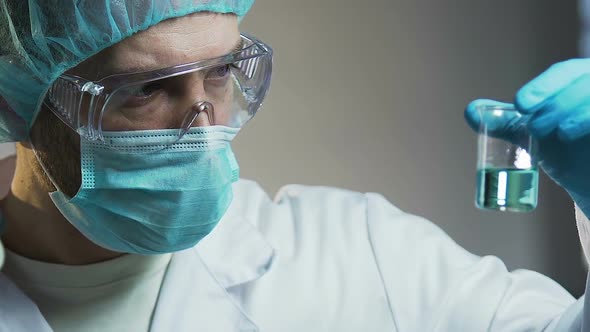 Male Lab Assistant Looking at Liquid Sample, Experiments on Household Chemicals