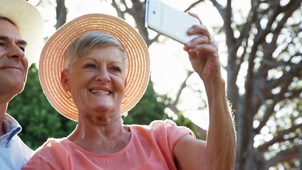 Senior couple taking selfie form mobile phone in park
