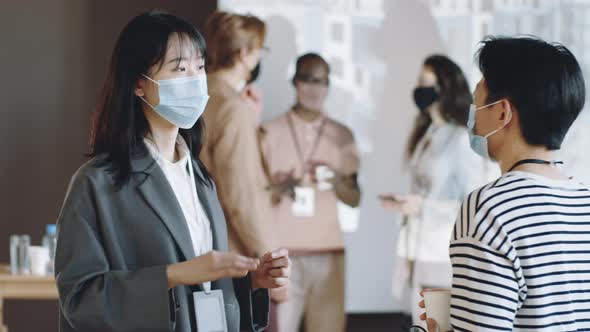 Asian Women in Masks Talking on Business Event