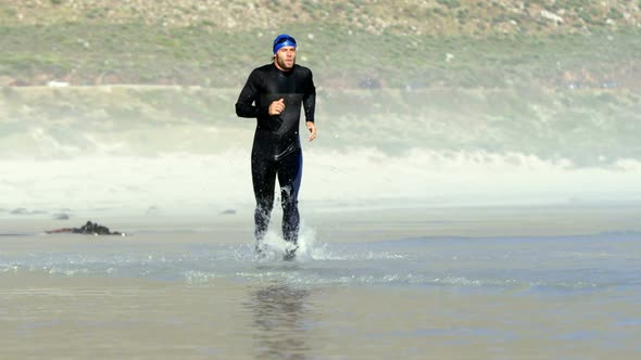 Male surfer running in the beach