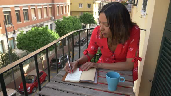 A woman writing in a journal diary traveling in a luxury resort town in Italy, Europe
