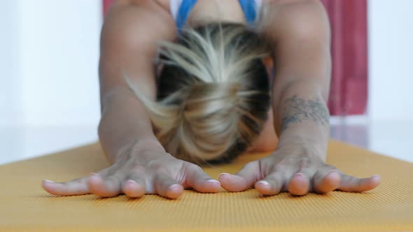 Girl Relaxing in Pose of Child on Rug, Stretching Out Hands on Mat, Tilts Head To Floor, Slow Motion