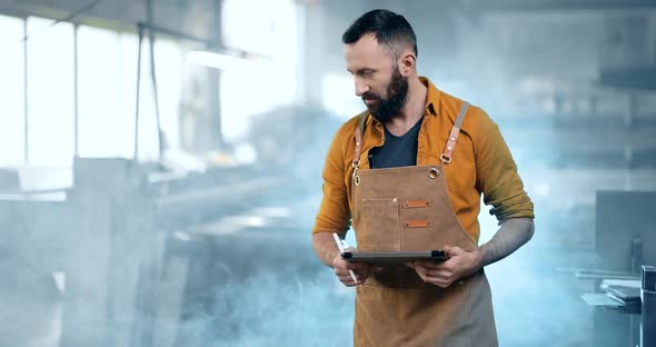 Factory Worker with Tablet and Phone at the Manufacturing