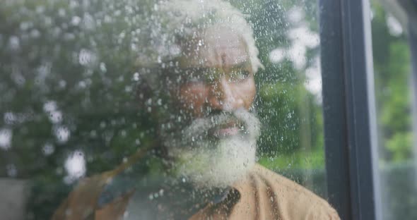 Video of sad african american senior man looking out the window