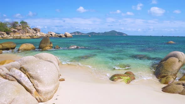 Slow motion: Gorgeous tropical beach turquoise transparent water unique rock boulders, Cam Ranh Nha alt
