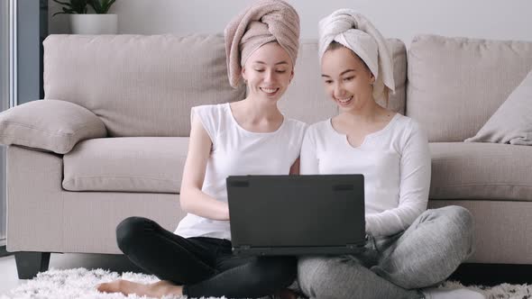 Two Girls Sitting at Home and Using Laptop