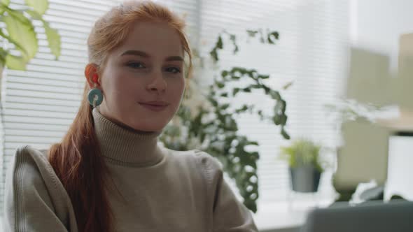 Portrait of Pretty Businesswoman Smiling at Camera in Office