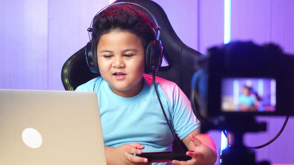 Asian Little Boy Hold Phone And Read Comment In Laptop Then Talking To Camera While Live Stream