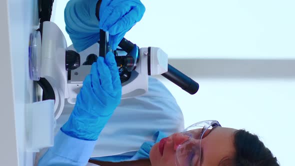 Vertical Video Scientist Placing a Slide on Specimen Stage of a Laboratory Microscope