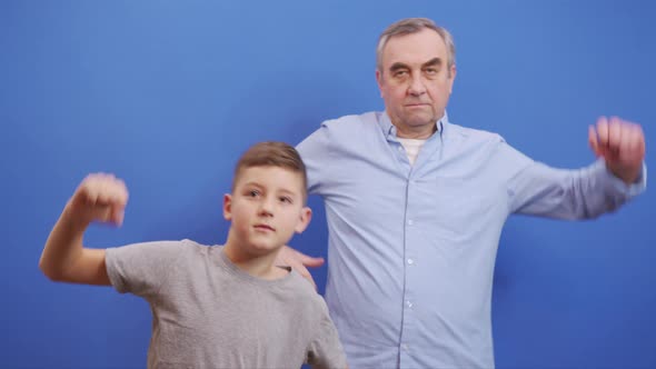 Grandfather with Grandson Doing Warmup on Blue Background