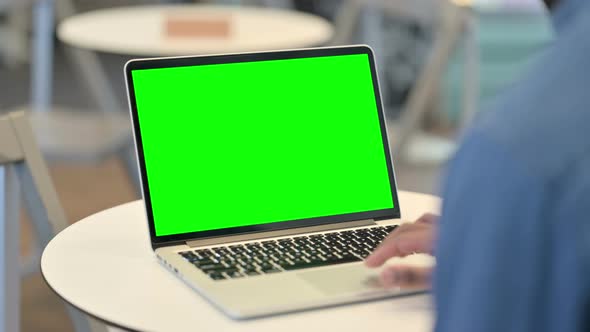 Man Working on Laptop with Green Chroma Key Screen Rear View