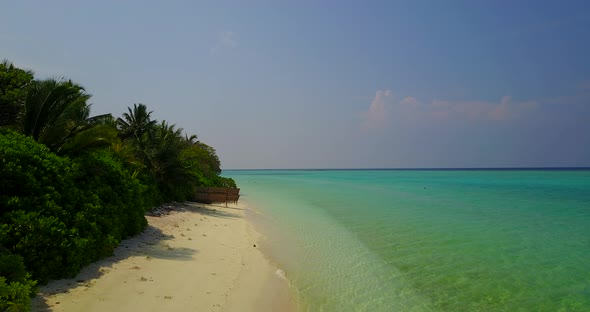 Wide angle fly over clean view of a sunshine white sandy paradise beach and turquoise sea background
