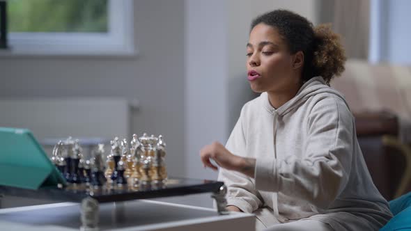 Focused Intelligent Player Making Move in Chess Game and Talking at Tablet Webcam